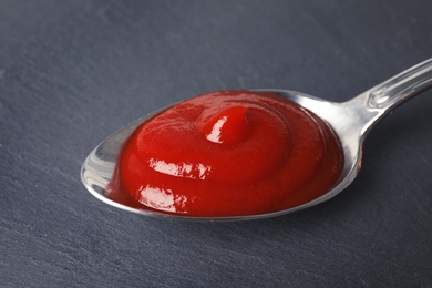 Photo of Homemade tomato sauce in metal spoon on table