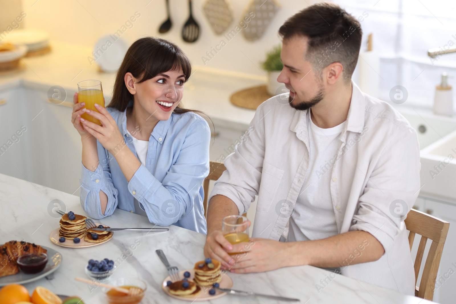 Photo of Happy couple having tasty breakfast at home