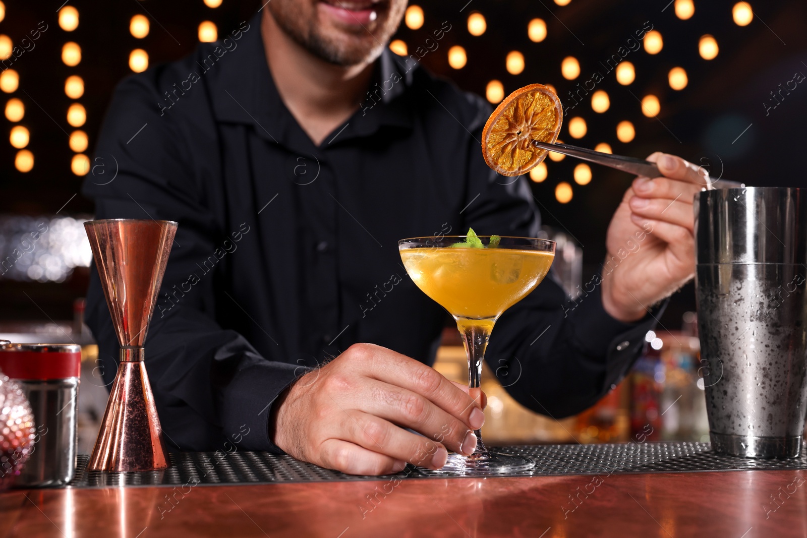 Photo of Bartender preparing fresh alcoholic cocktail in bar