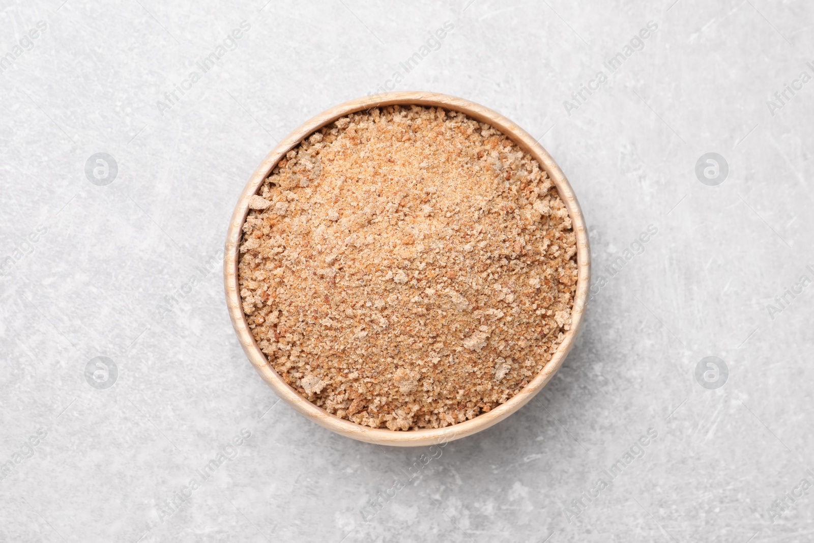 Photo of Fresh bread crumbs in bowl on grey table, top view