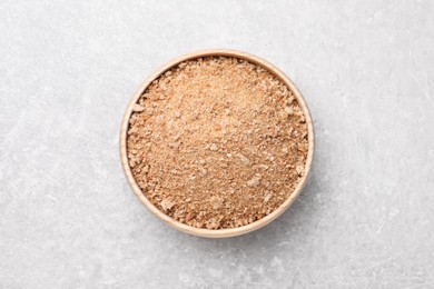 Photo of Fresh bread crumbs in bowl on grey table, top view