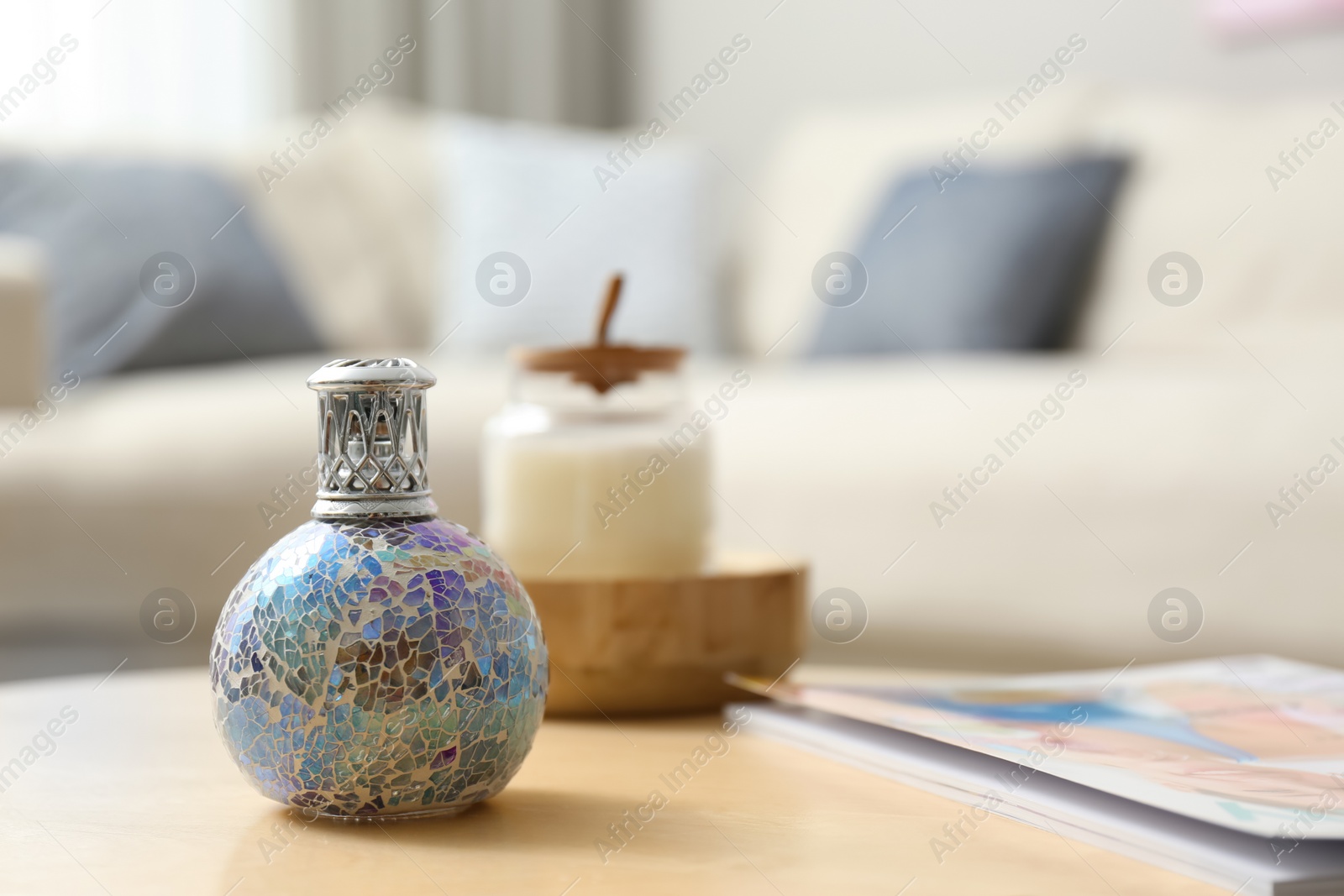 Photo of Stylish catalytic lamp on wooden table in living room, space for text. Cozy interior