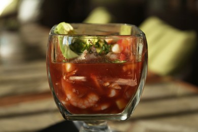 Photo of Delicious campechana cocktail with shrimps on table, closeup