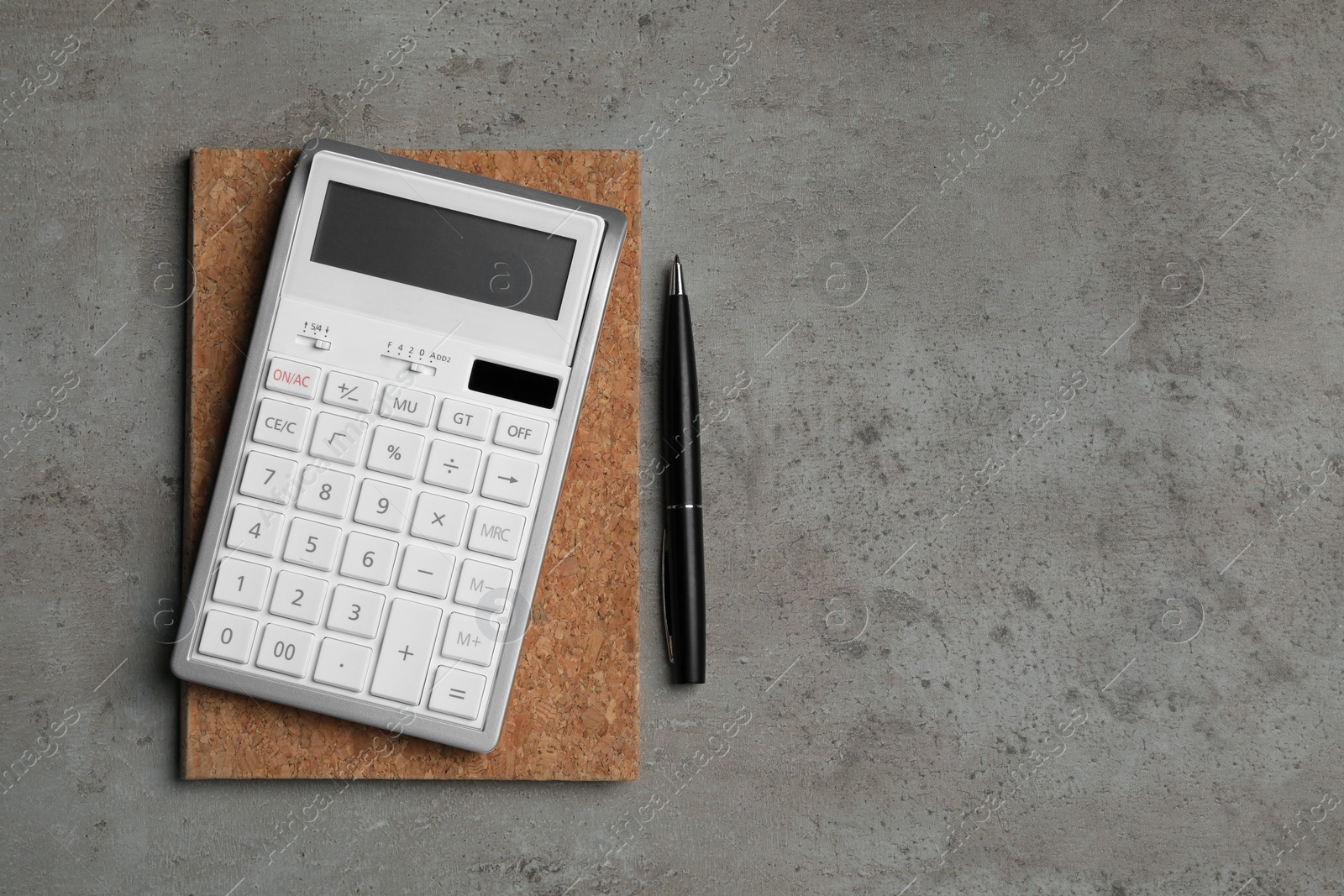 Photo of Calculator, notebook and pen on grey table, flat lay with space for text