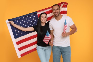 4th of July - Independence Day of USA. Happy couple with American flags on yellow background