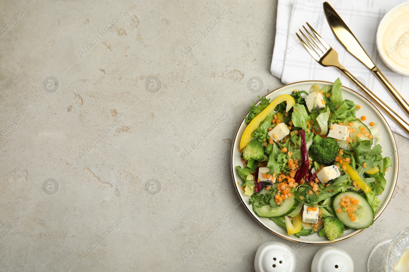 Photo of Delicious salad with lentils, vegetables and cheese served on light grey table, flat lay. Space for text