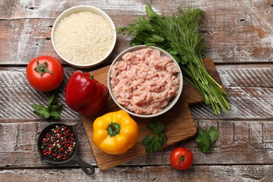 Photo of Making stuffed peppers. Ground meat and other ingredients on wooden table, flat lay