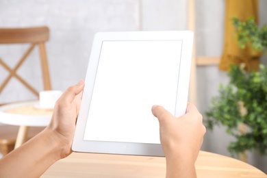 Photo of Woman working with modern tablet indoors, closeup. Space for design