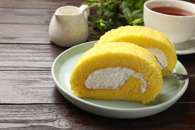 Delicious cake roll served on wooden table, closeup