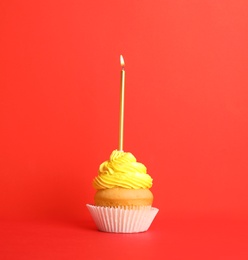 Birthday cupcake with candle on red background