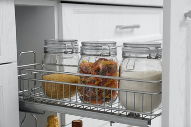 Open drawer with jars of food in kitchen