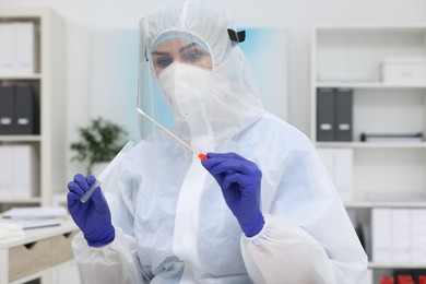 Photo of Laboratory testing. Doctor in uniform with cotton swab and tube at hospital