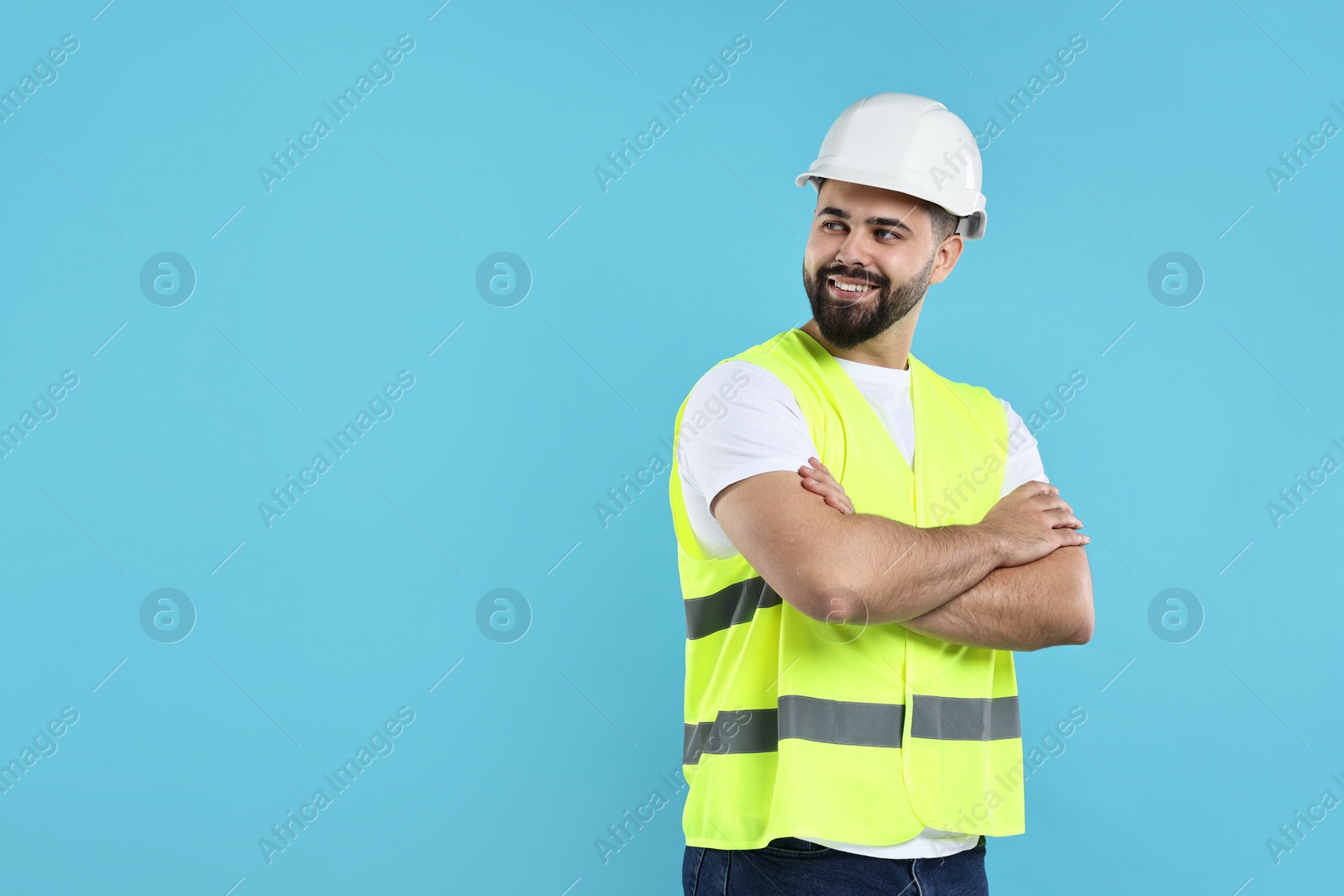 Photo of Engineer in hard hat on light blue background, space for text