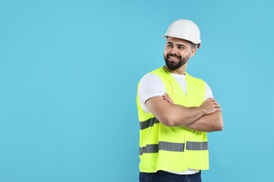 Photo of Engineer in hard hat on light blue background, space for text