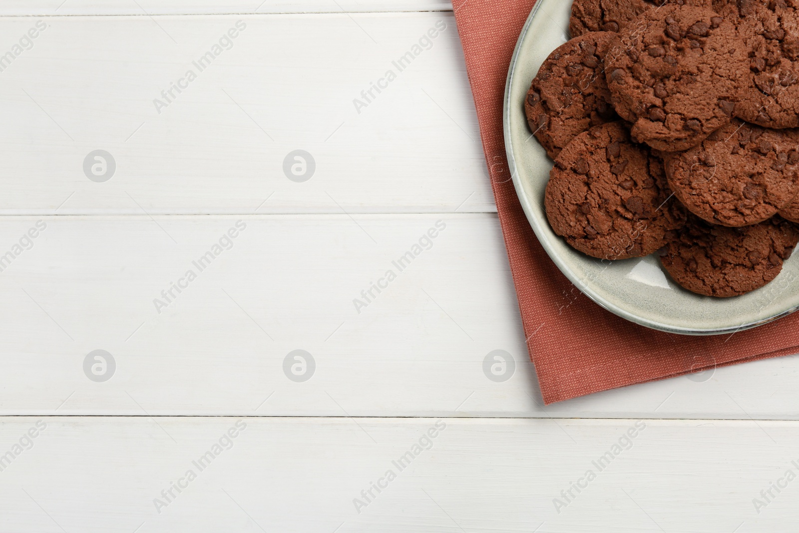 Photo of Delicious chocolate chip cookies on white wooden table, top view. Space for text