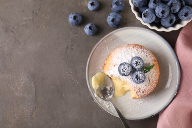 Photo of Tasty vanilla fondant with white chocolate and blueberries on grey table, flat lay. Space for text