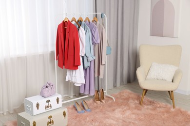 Photo of Clothing rack with stylish women's clothes on hangers in boutique
