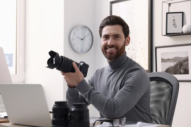 Professional photographer with digital camera at table in office