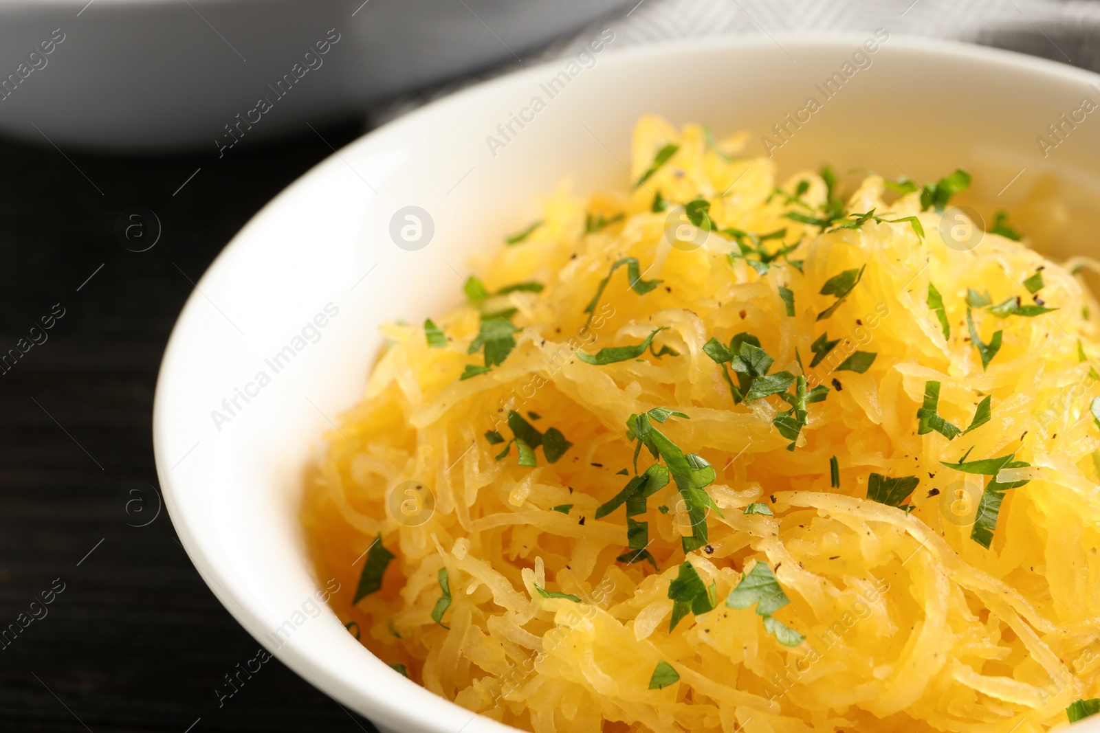 Photo of Bowl with cooked spaghetti squash on table, closeup