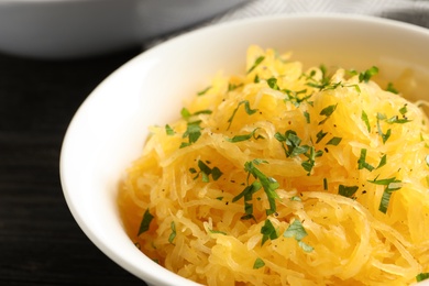 Bowl with cooked spaghetti squash on table, closeup