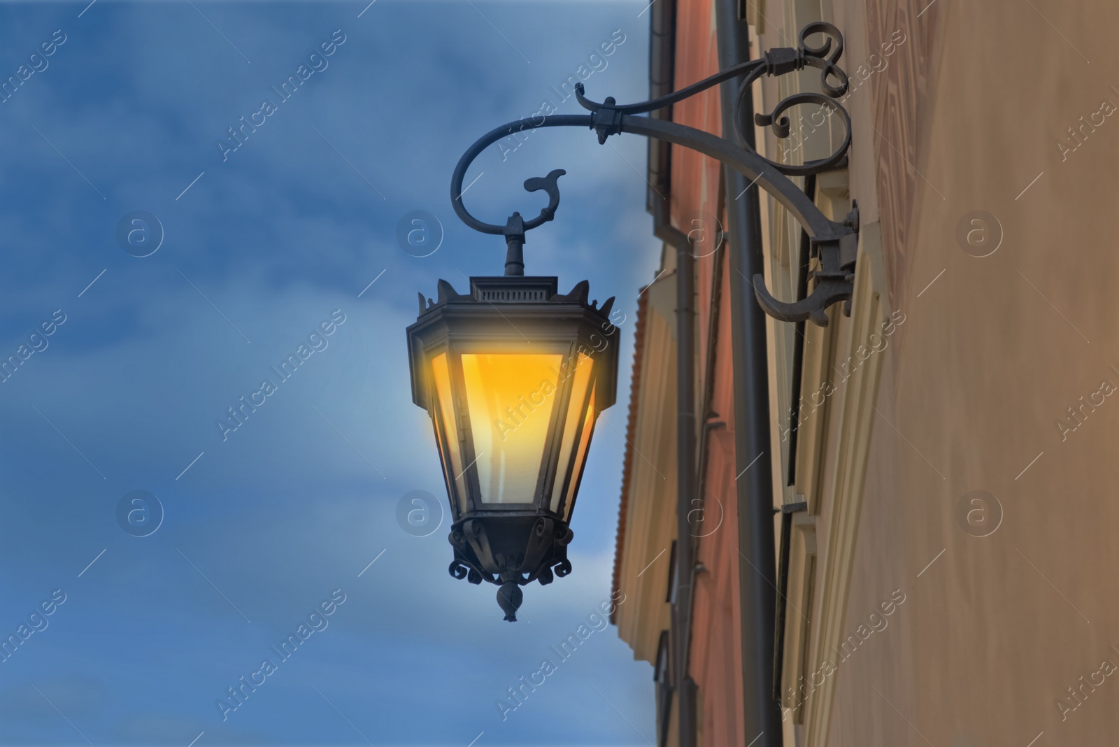 Image of Beautiful old fashioned street lamp lighting on wall of building