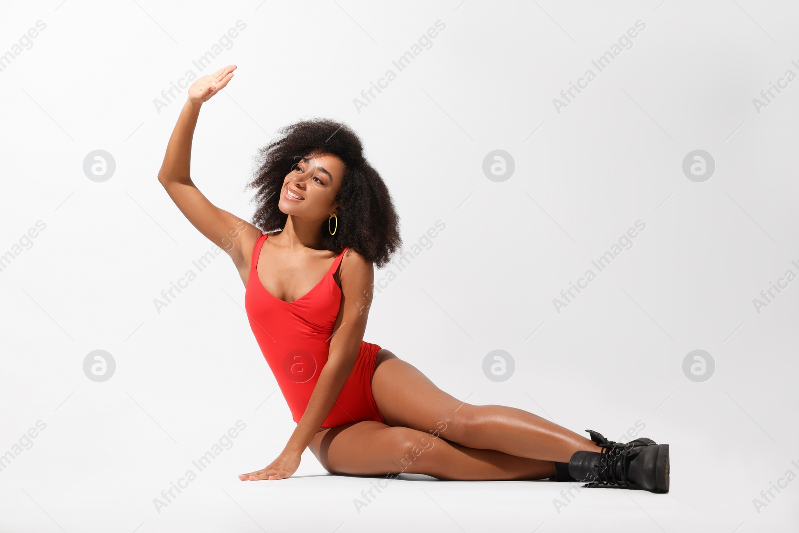 Photo of Beautiful woman in red one-piece summer swimsuit posing on white background