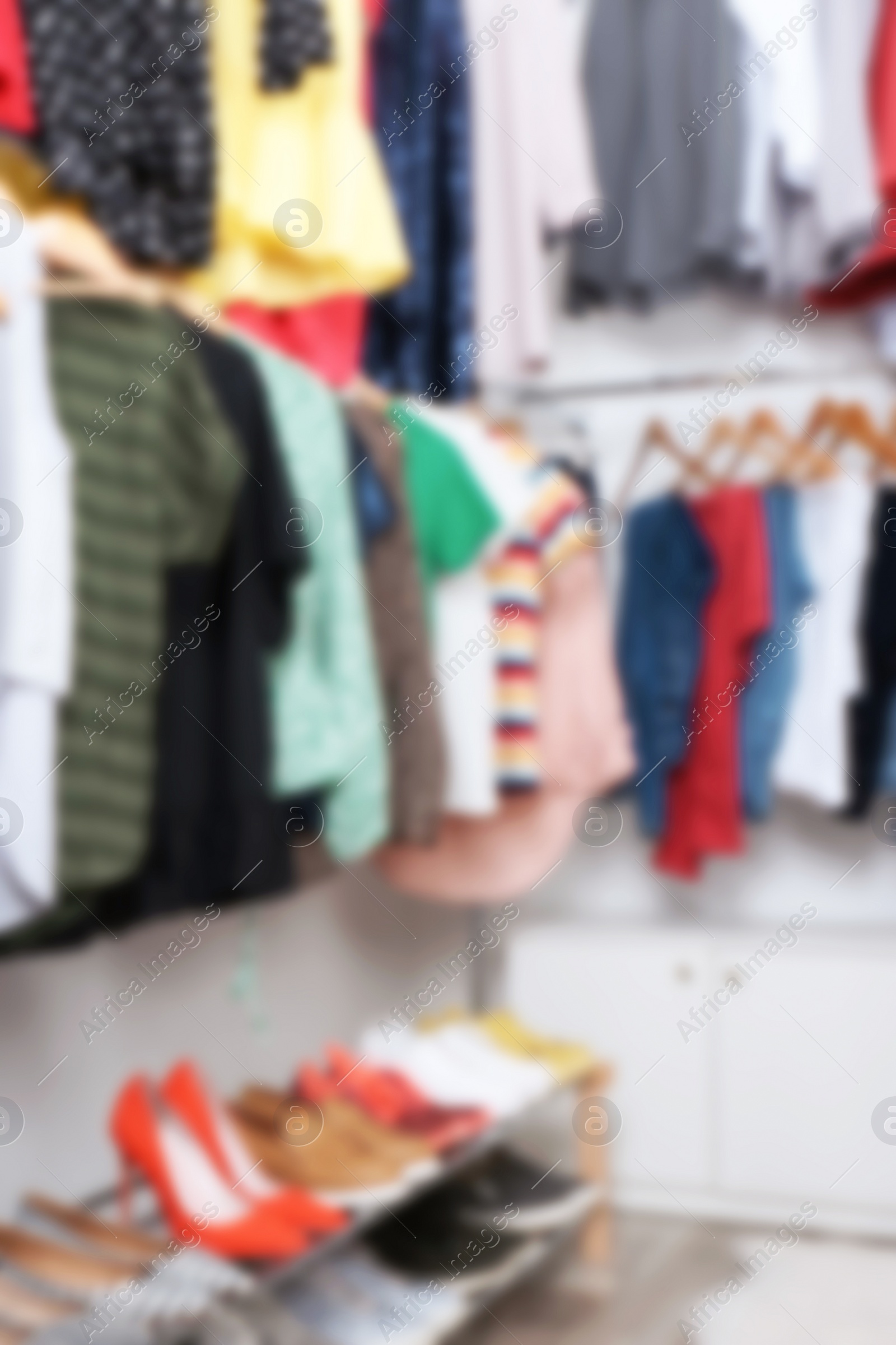 Photo of Blurred view of dressing room with different clothes and shoes