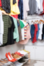 Photo of Blurred view of dressing room with different clothes and shoes