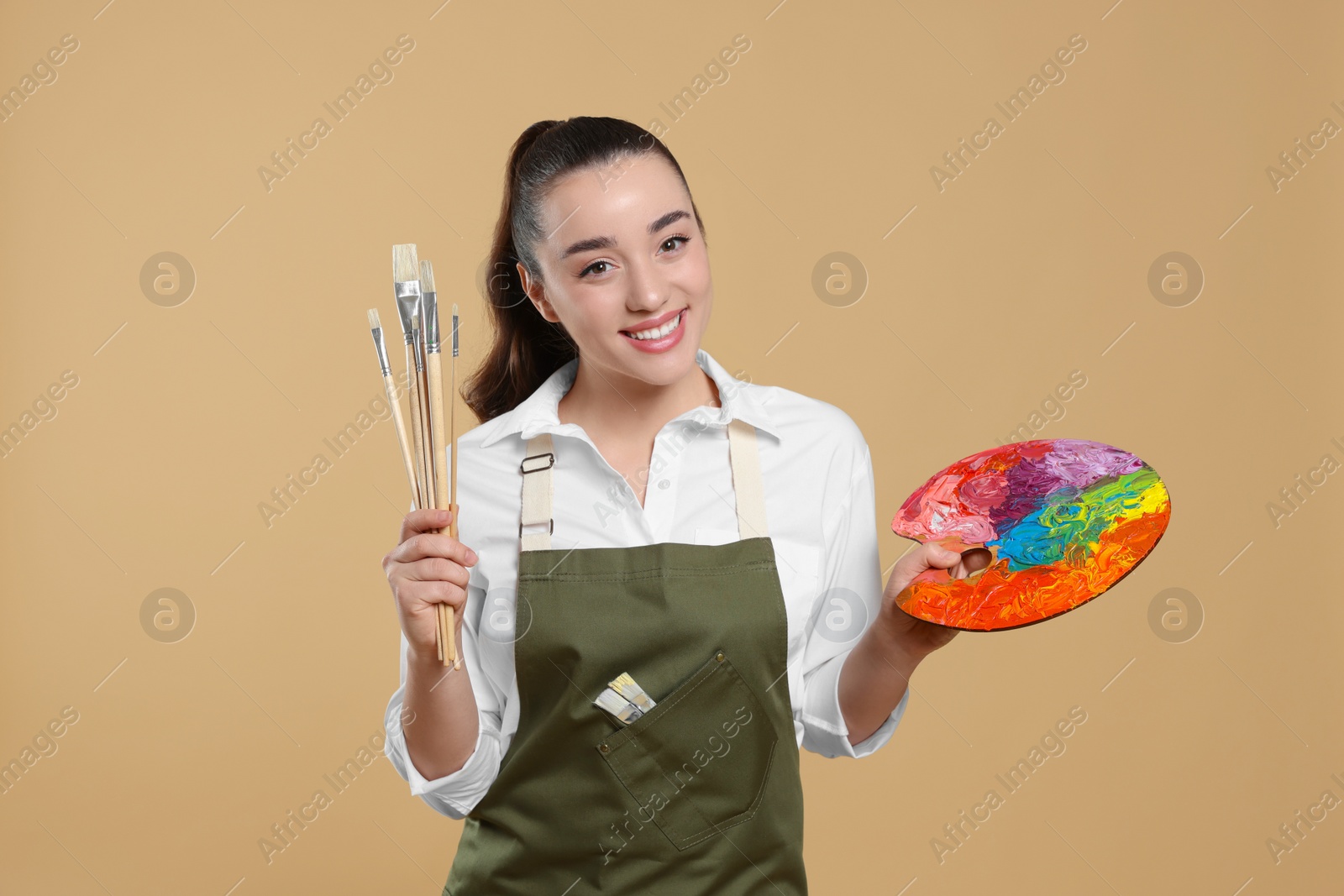 Photo of Woman with painting tools on beige background. Young artist