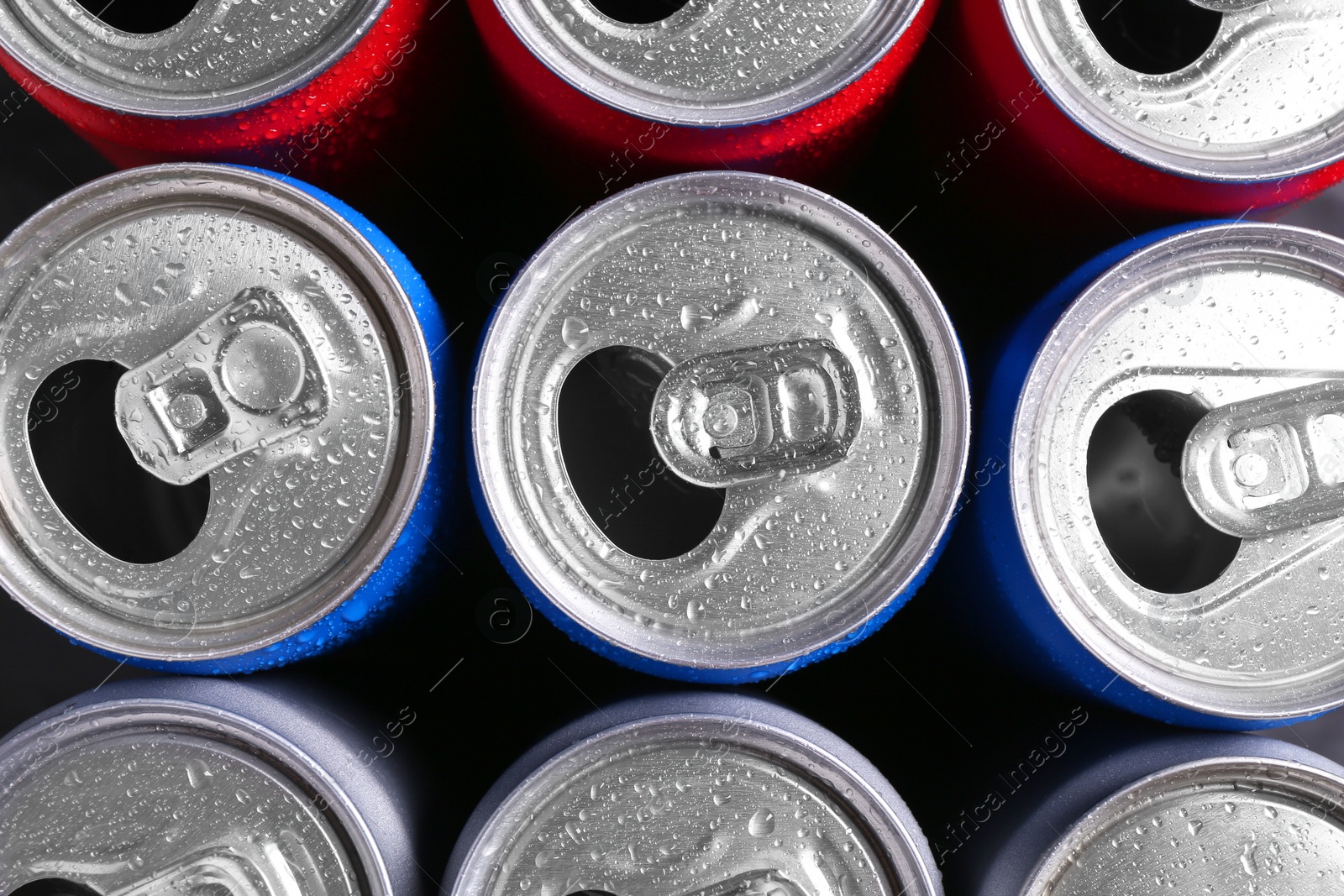 Photo of Energy drinks in wet cans as background, top view. Functional beverage