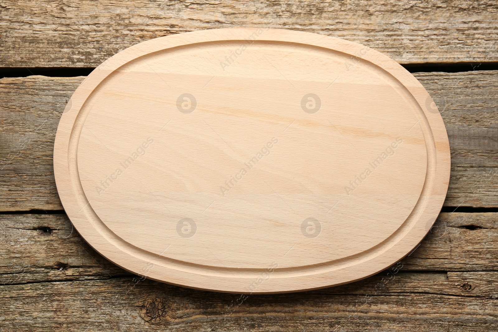 Photo of One new cutting board on old wooden table, top view