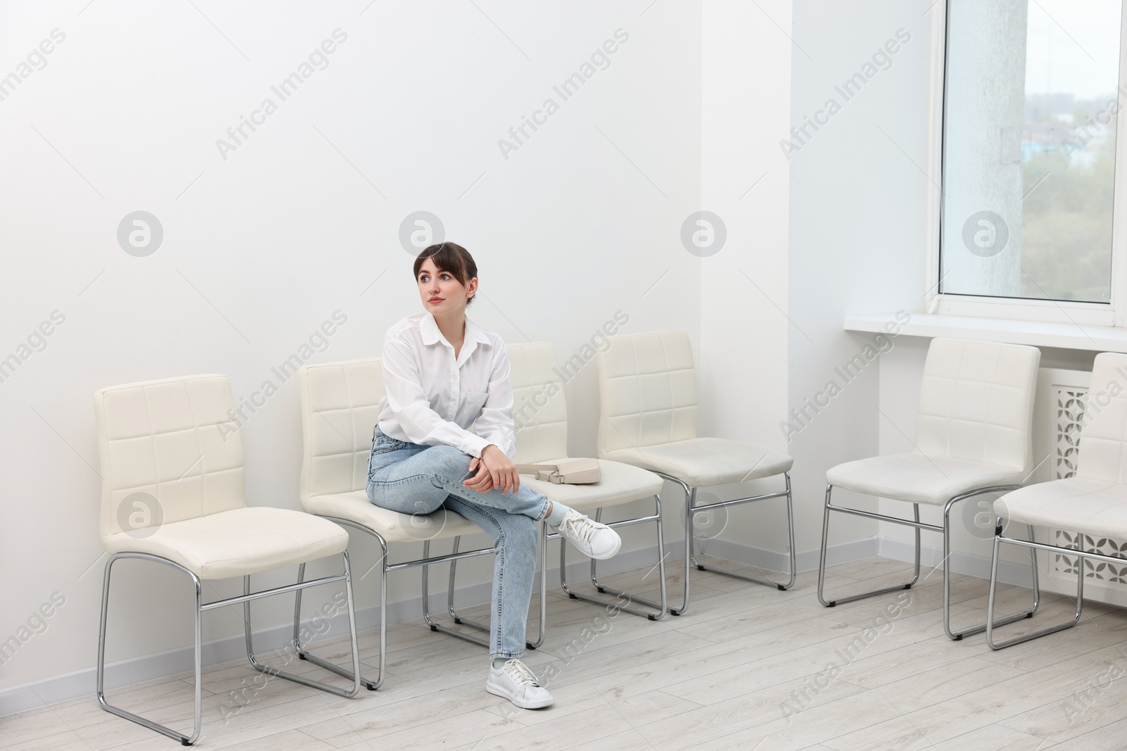Photo of Woman sitting on chair and waiting for job interview indoors