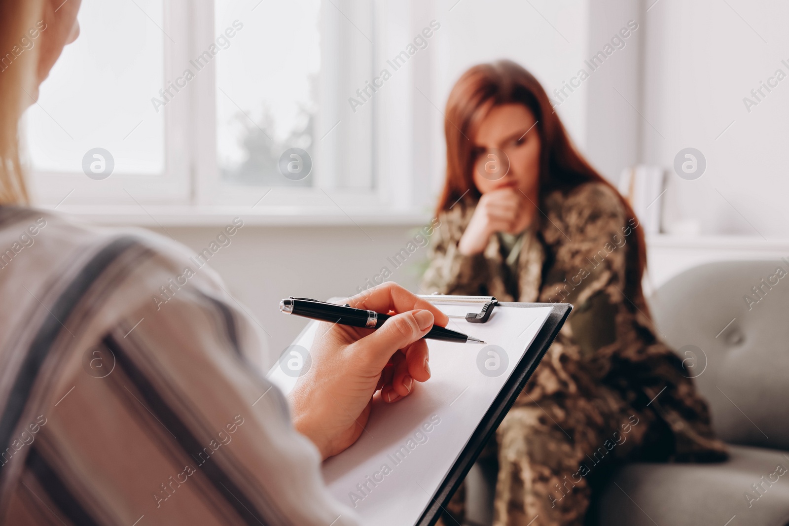 Photo of Psychologist working with military officer in office, focus on hand