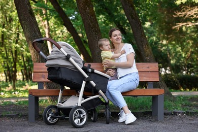 Photo of Happy nanny with cute little boy on bench in park