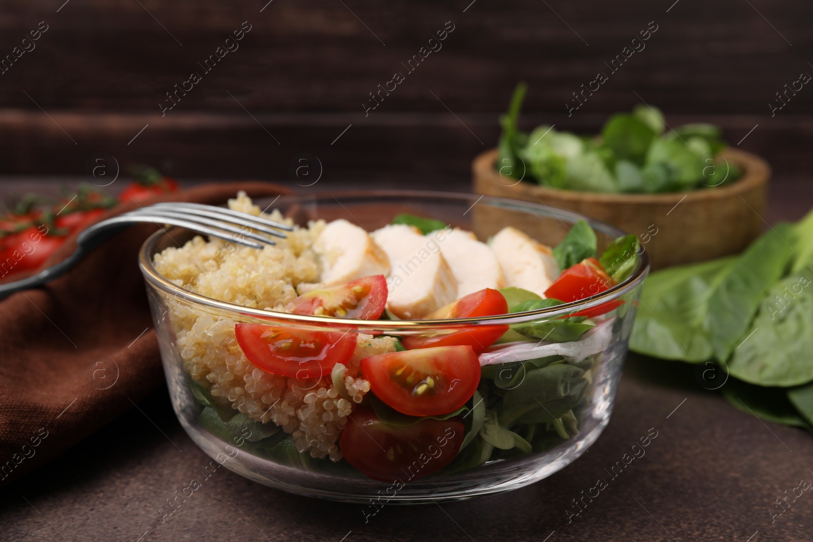 Photo of Delicious quinoa salad with chicken and cherry tomatoes served on grey textured table, closeup