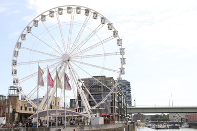 Photo of Cologne, Germany - August 28, 2022: Picturesque view of Ferris wheel in city near canal, space for text