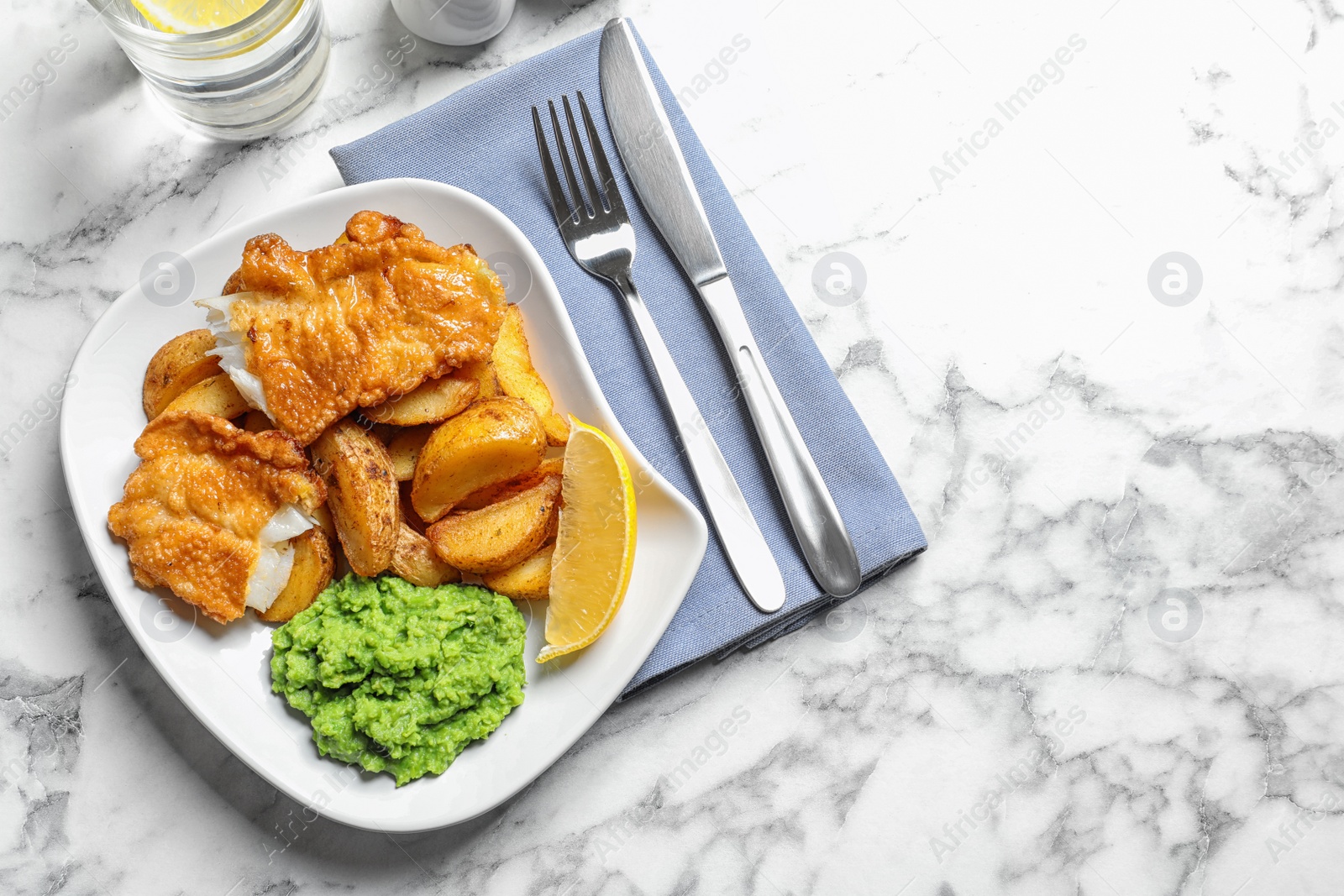 Photo of Plate with British traditional fish and potato chips on marble background, top view. Space for text