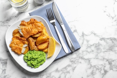 Plate with British traditional fish and potato chips on marble background, top view. Space for text