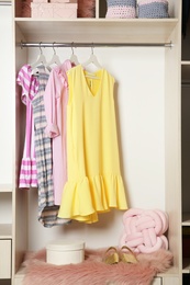 Photo of Wardrobe with stylish girl's clothes hanging on rack