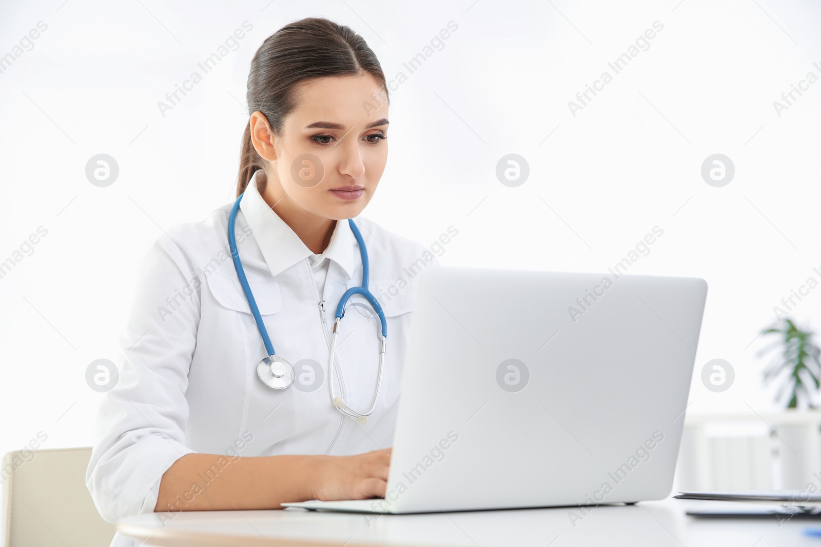 Photo of Female doctor working with laptop at table. Cardiology center