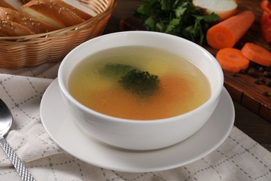 Photo of Tasty soup with vegetables in bowl served on wooden table, closeup