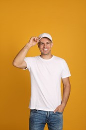 Happy man in white cap and tshirt on yellow background. Mockup for design
