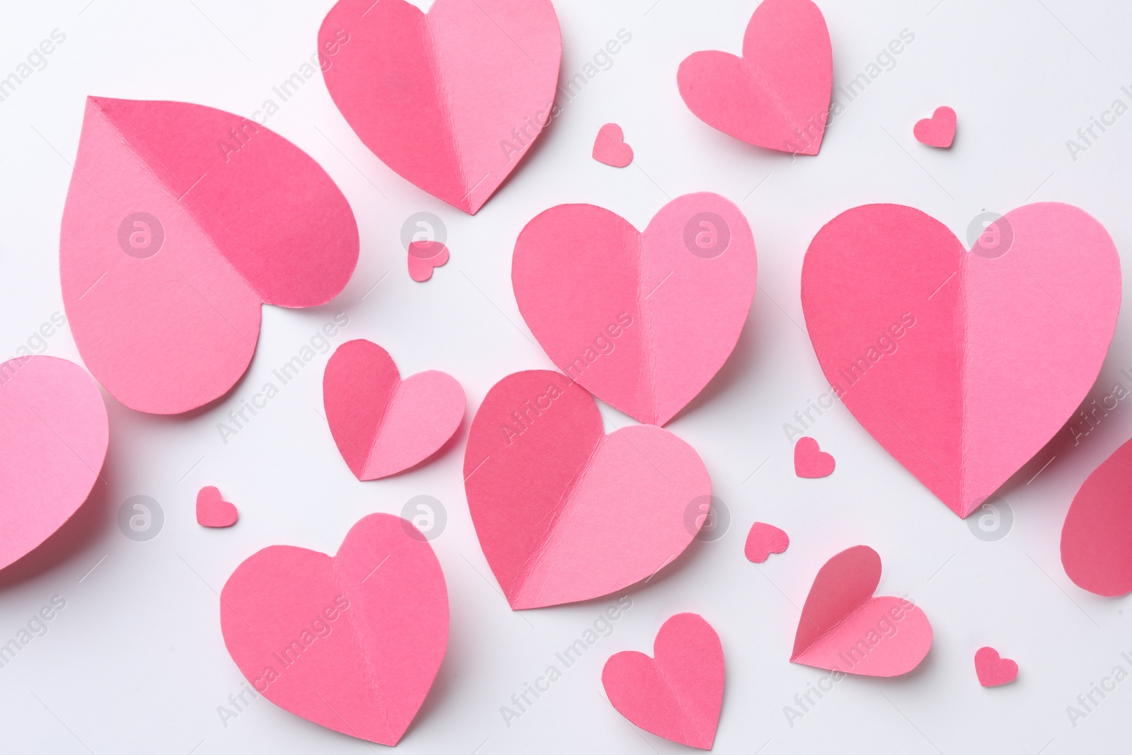 Photo of Pink paper hearts on white background, flat lay