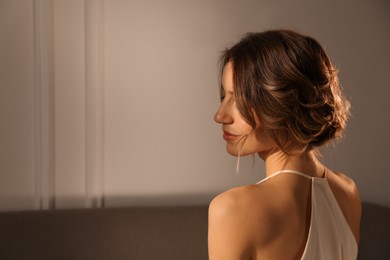 Young woman with beautiful hairstyle indoors. Space for text