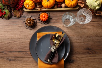 Photo of Thanksgiving table setting. Plates, cutlery, glasses and autumn decor, flat lay