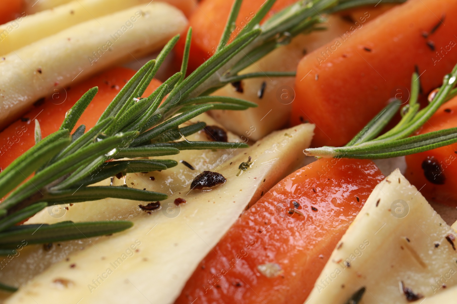 Photo of Slices of parsnip and carrot with rosemary, closeup