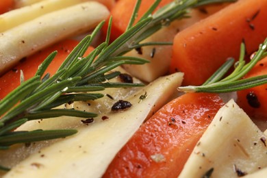 Photo of Slices of parsnip and carrot with rosemary, closeup