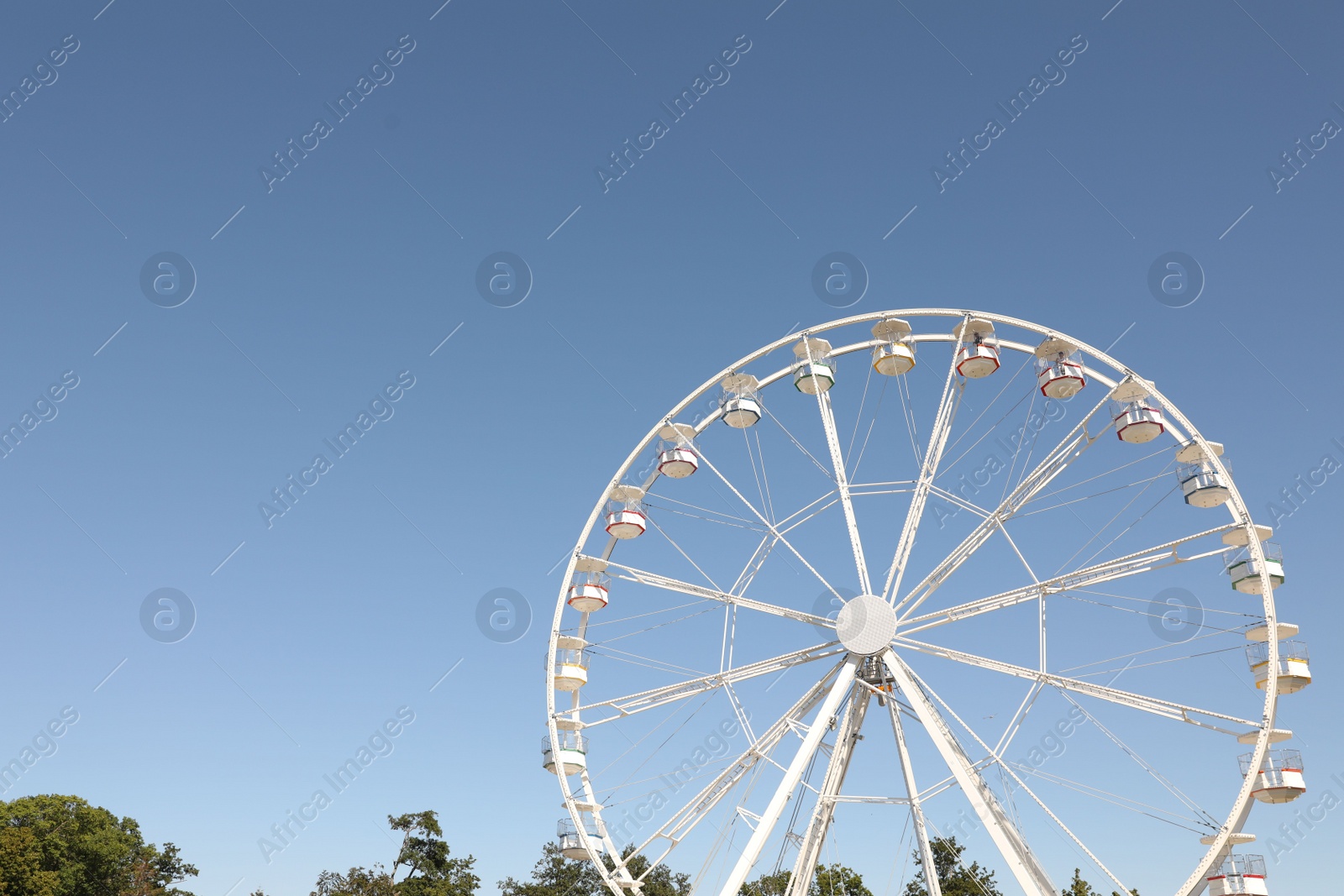 Photo of Beautiful white ferris wheel against blue sky, space for text