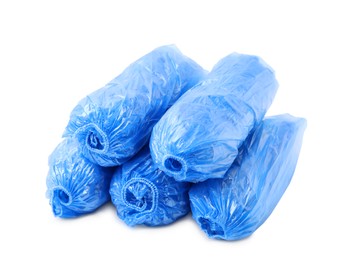 Photo of Many rolled blue shoe covers isolated on white