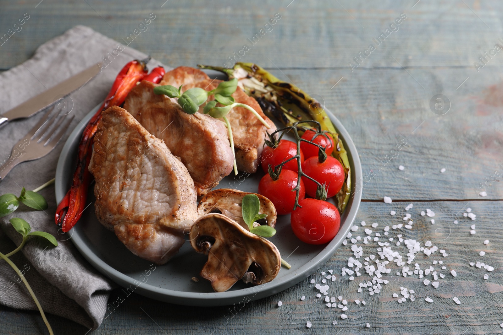 Photo of Delicious grilled meat and vegetables served on wooden table, space for text